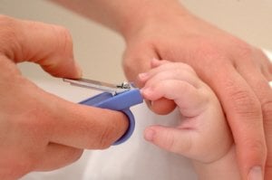 Una madre corta las uñas a su bebé