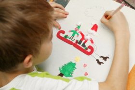 Un niño realiza un dibujo de Navidad